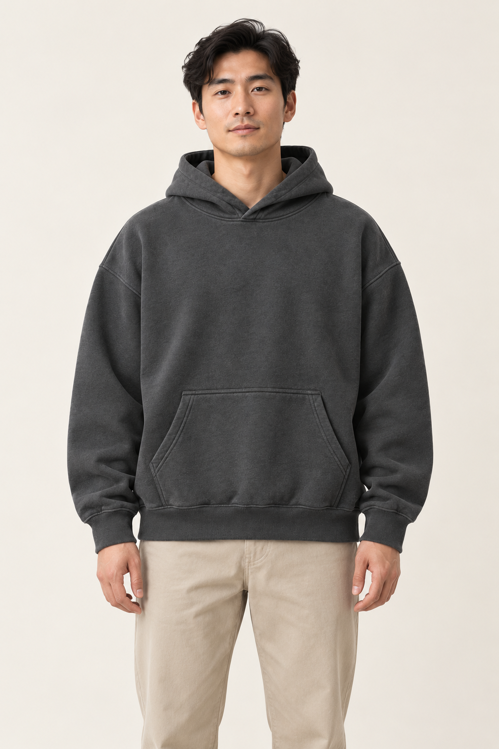 Adult man wearing the COMMON FORM Men's Essential Hoodie in Charcoal.