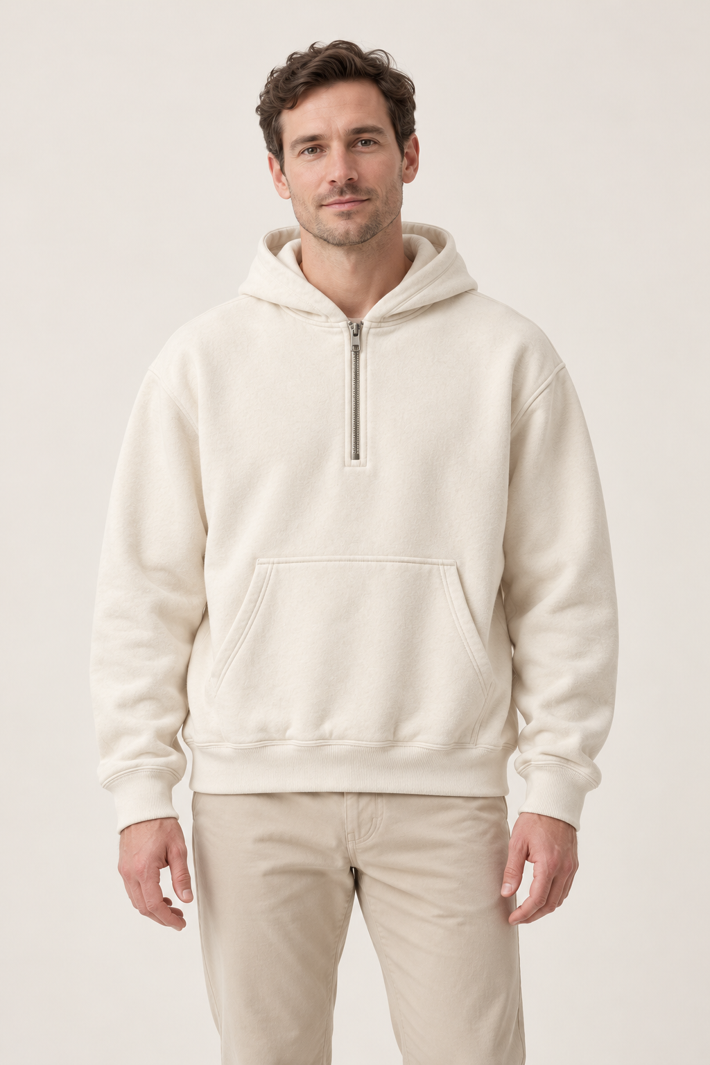 Adult man wearing the COMMON FORM Men's Half Zip Hoodie in Cream.