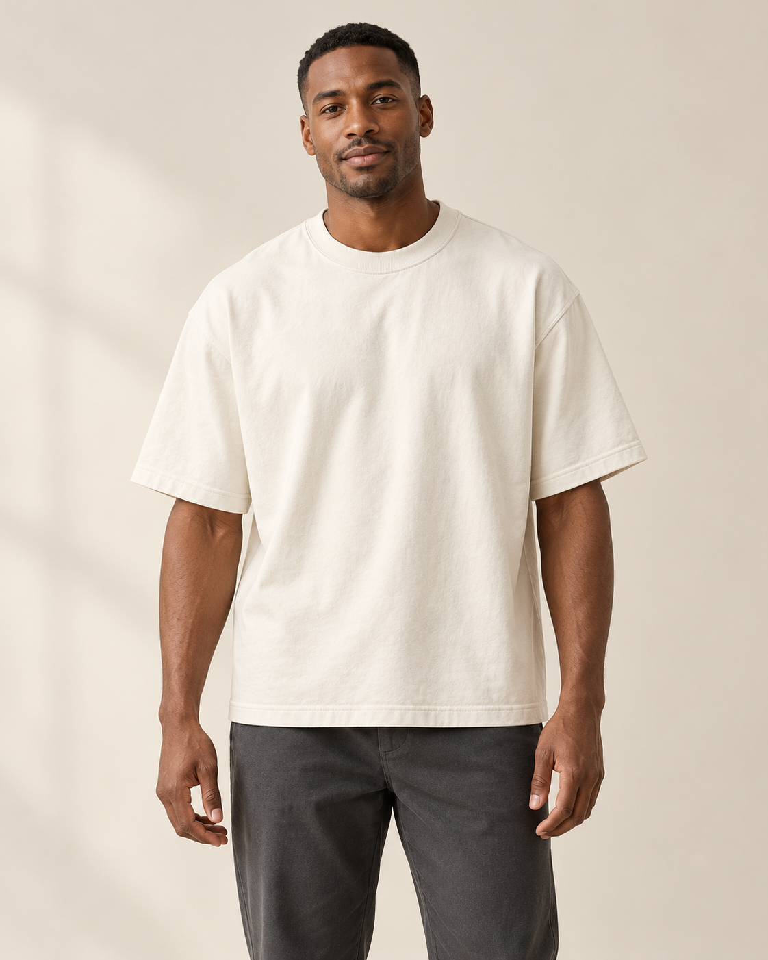 Adult man wearing the COMMON FORM Men's Heavyweight Tee in Cream.