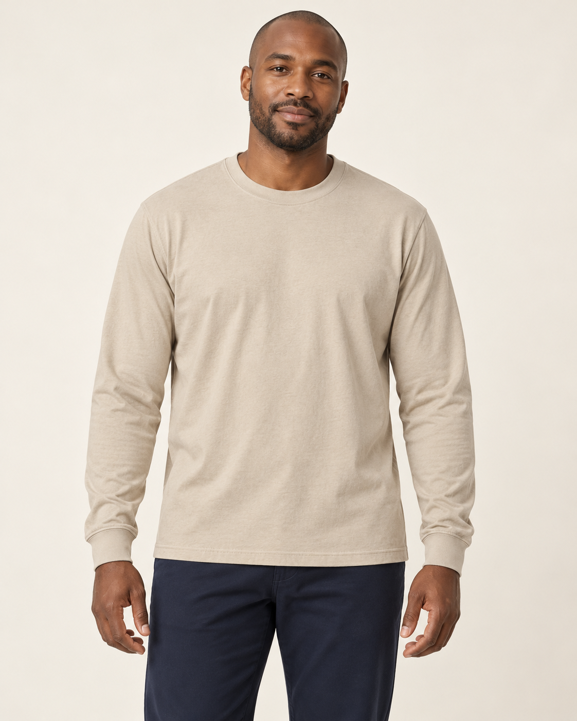 Adult man wearing the COMMON FORM Men's Long Sleeve Tee in Stone.