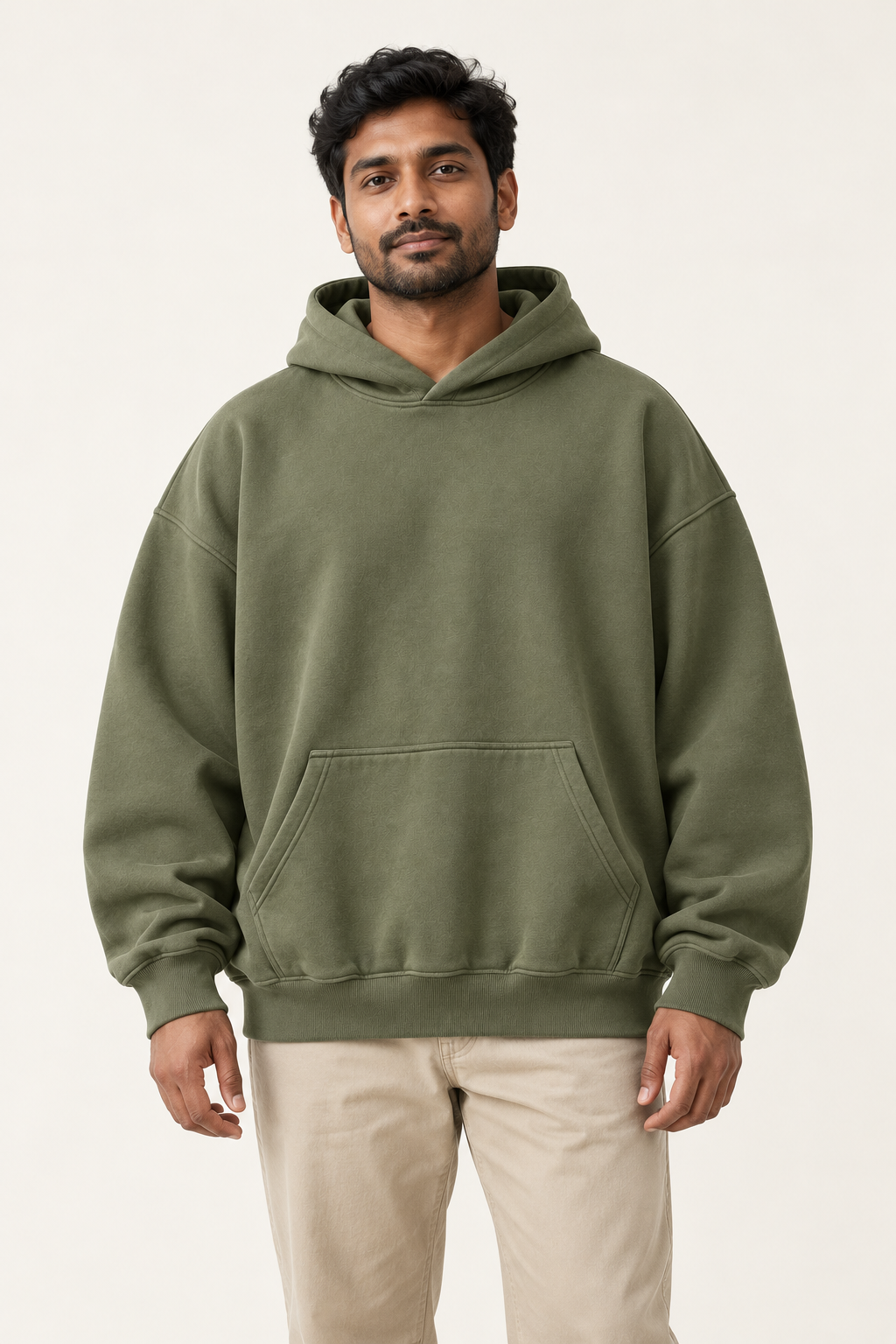 Adult man wearing the COMMON FORM Men's Oversized Hoodie in Olive.