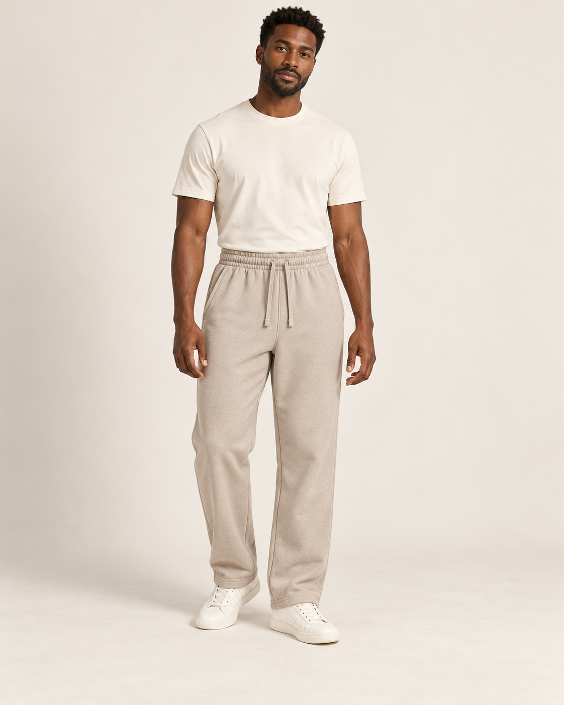 Adult man wearing the COMMON FORM Men's Straight Trackpants in Stone.