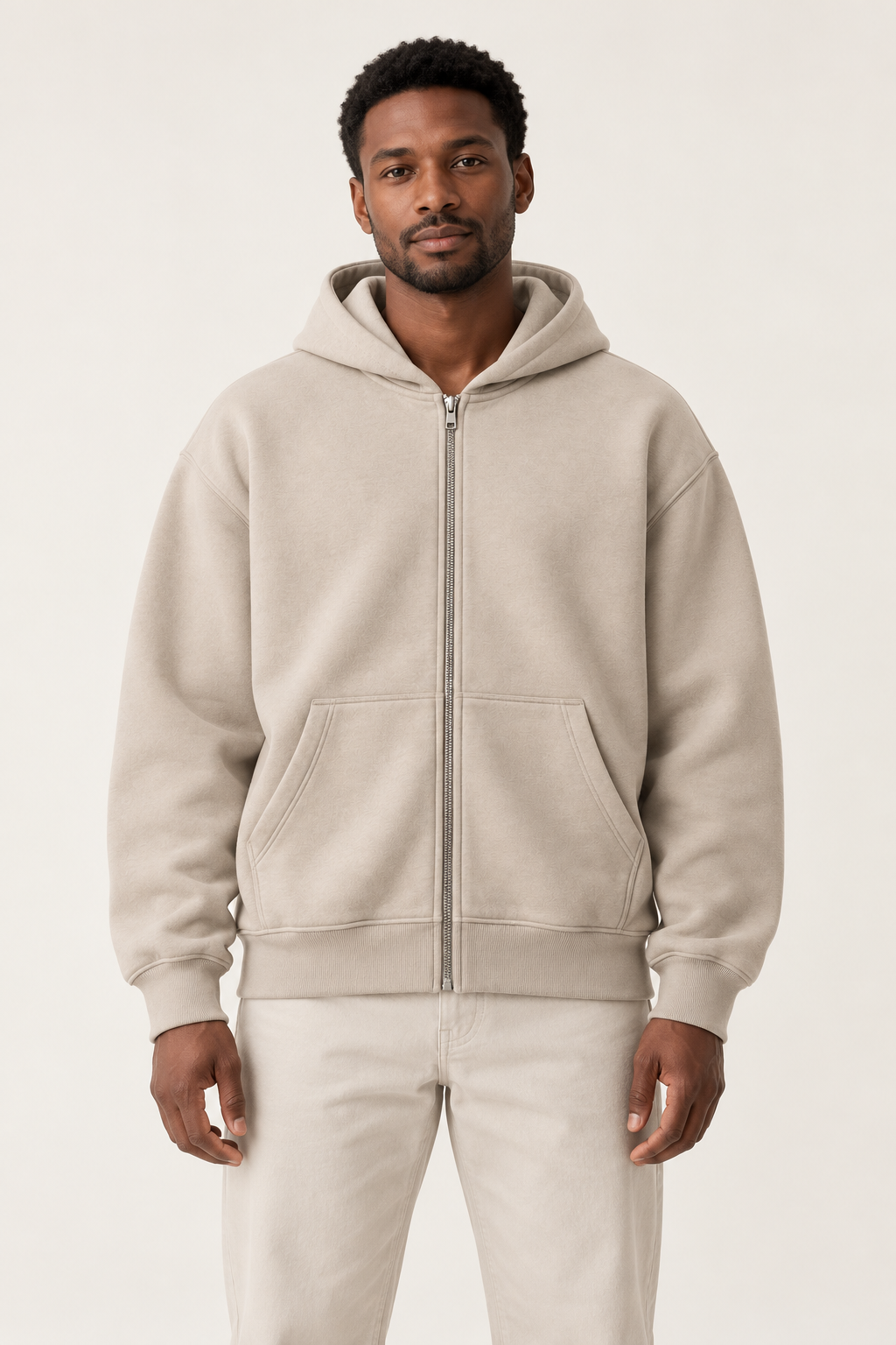 Adult man wearing the COMMON FORM Men's Zip Through Hoodie in Stone.