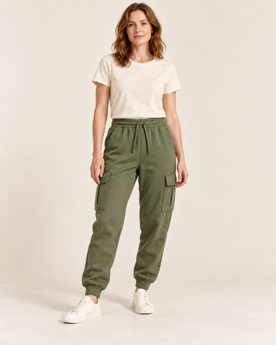Adult woman wearing the COMMON FORM Women's Cargo Trackpants in Olive.