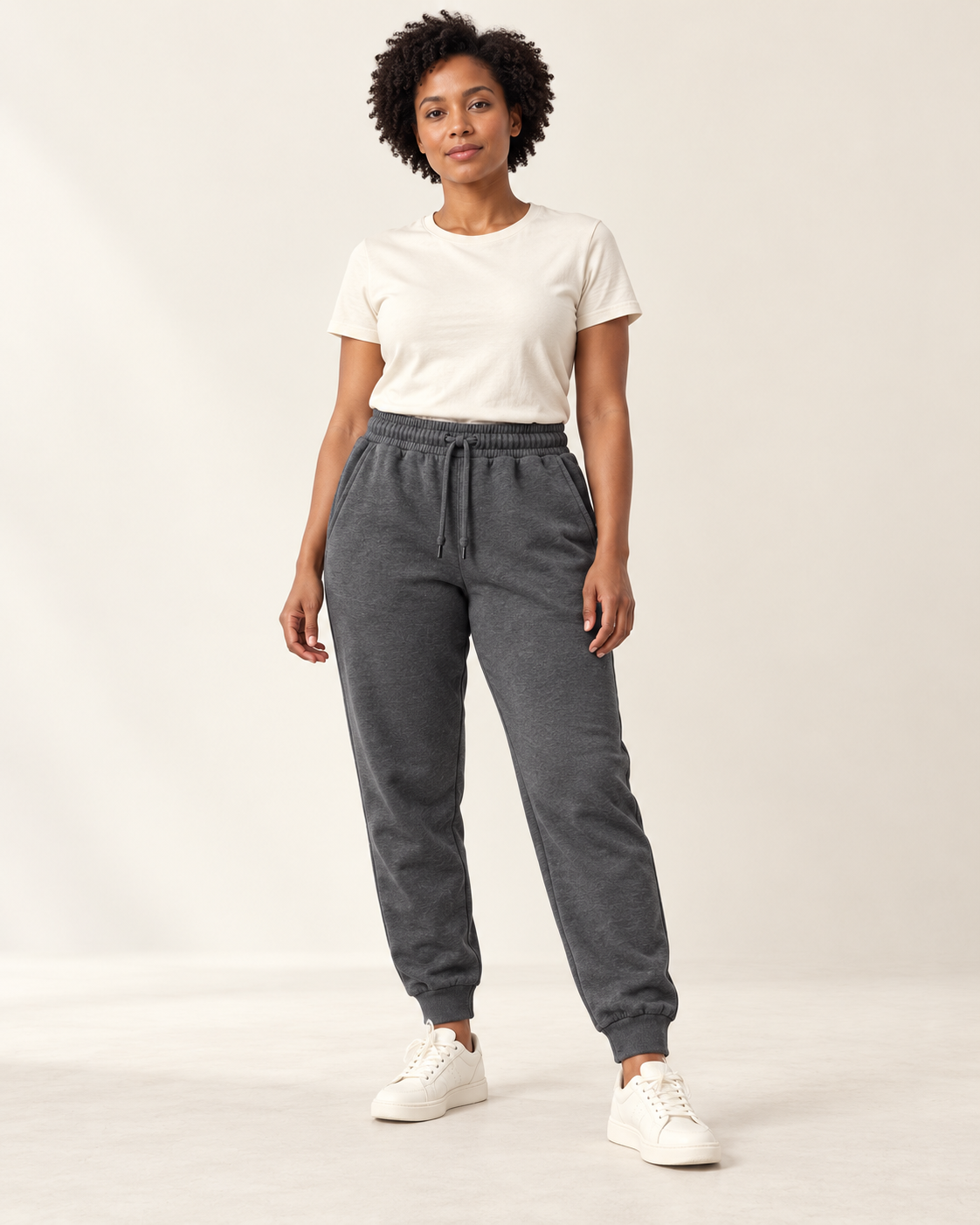 Adult woman wearing the COMMON FORM Women's Cuffed Trackpants in Charcoal.