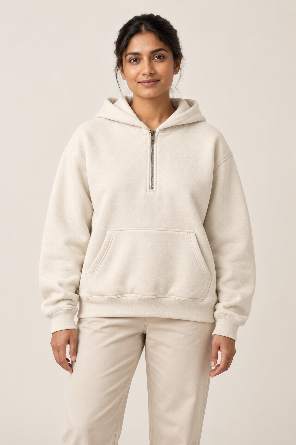 Adult woman wearing the COMMON FORM Women's Half Zip Hoodie in Cream.