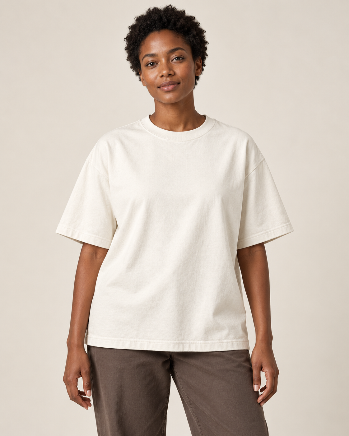 Adult woman wearing the COMMON FORM Women's Heavyweight Tee in Cream.