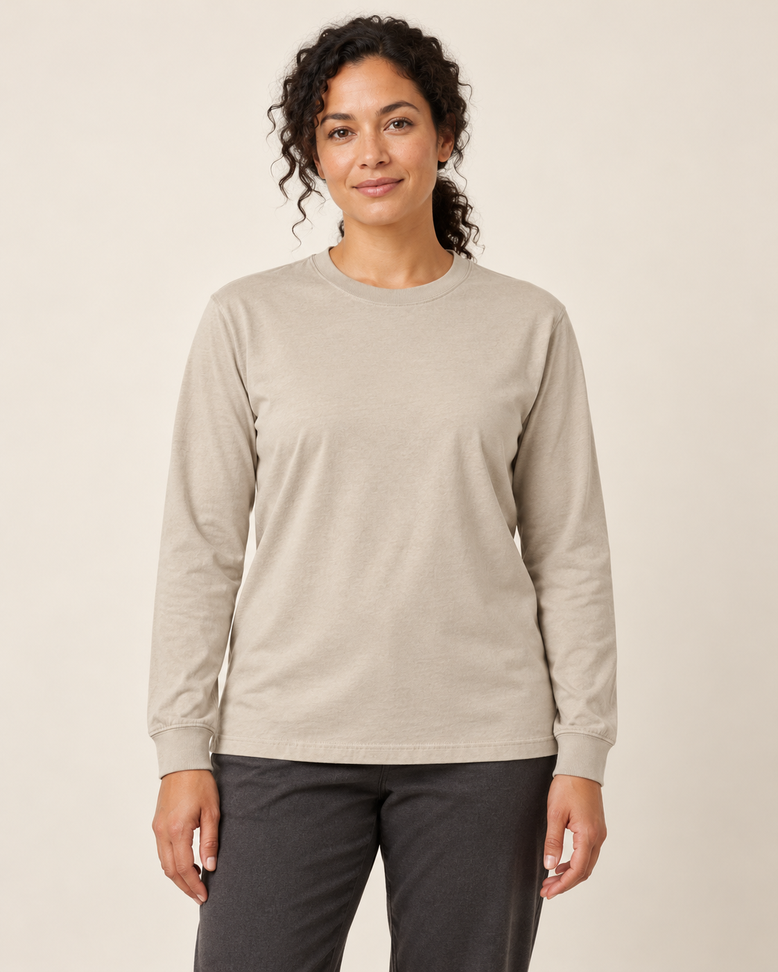 Adult woman wearing the COMMON FORM Women's Long Sleeve Tee in Stone.