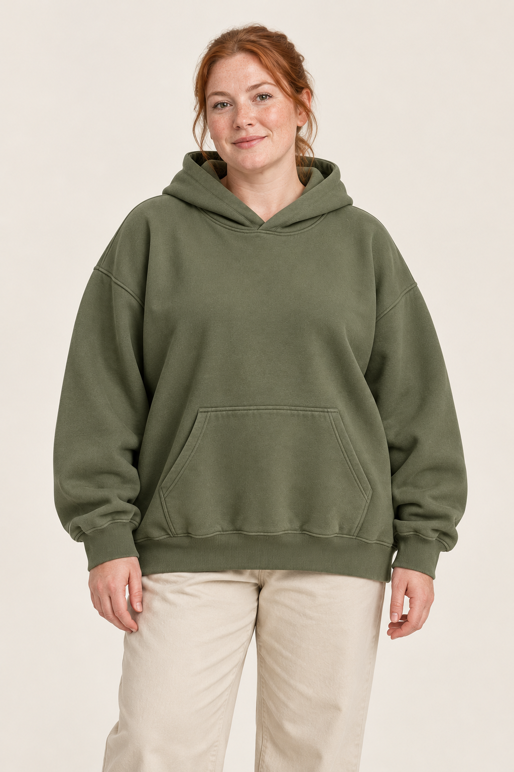 Adult woman wearing the COMMON FORM Women's Oversized Hoodie in Olive.