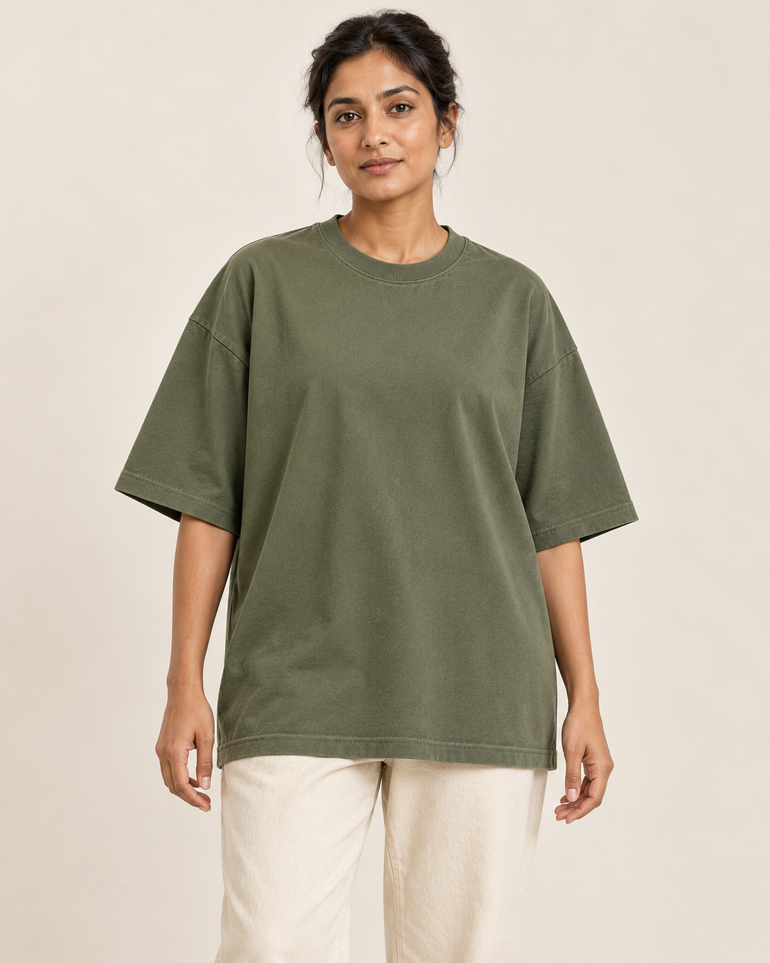 Adult woman wearing the COMMON FORM Women's Oversized Tee in Olive.