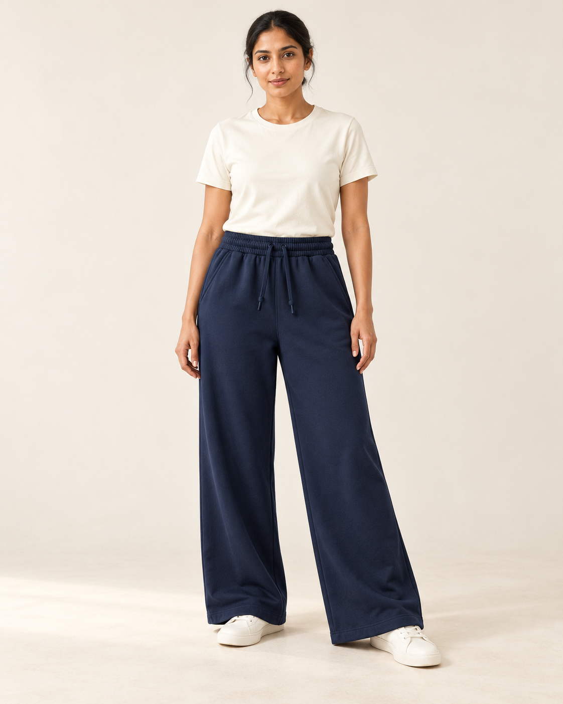 Adult woman wearing the COMMON FORM Women's Wide Leg Trackpants in Navy.
